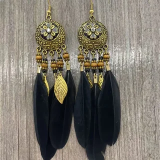 Two drop earrings with an embossed gold-tone floral disc, beaded sections, gold leaf charms, and long black plumes.