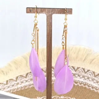 Breeze Feather Drops displayed on a jewelry stand, showing thin metal bars and soft purple feathers.