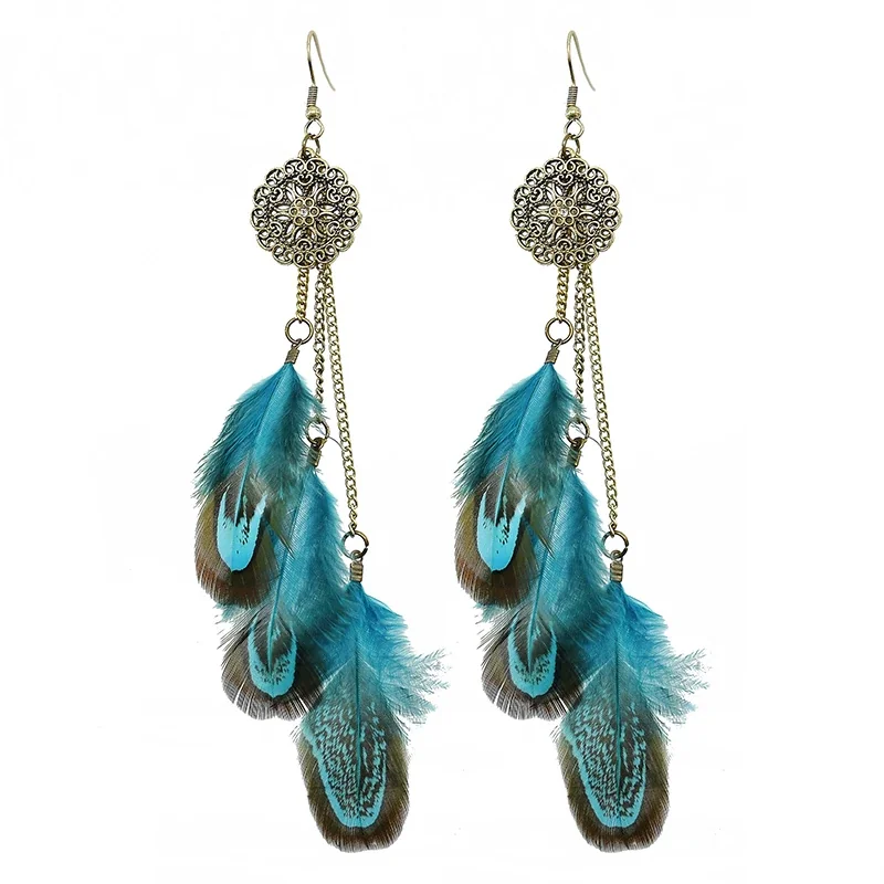 A pair of long, tiered feather drop earrings featuring ornate metal medallions at the top and hanging chains.