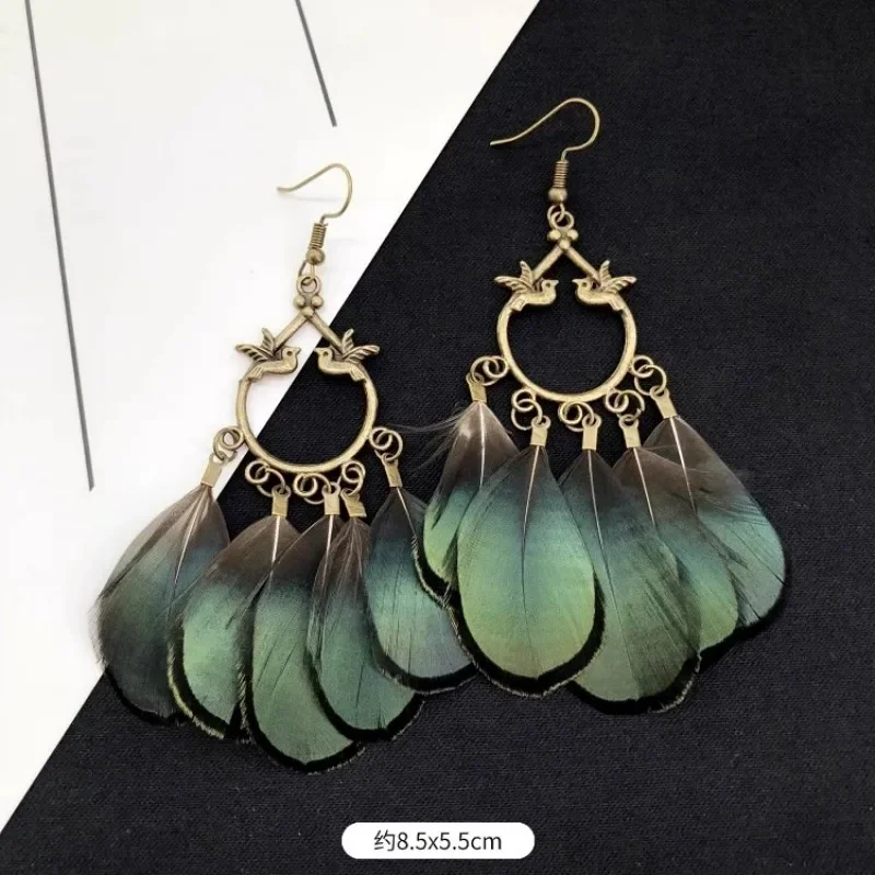 Feather fan drop earrings with a gold-toned open circular frame, a star-shaped outline, and overlapping green and dark feather shapes.