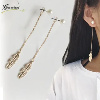 A pair of drop earrings featuring a spherical stud connected by a thin chain to a small, detailed metal feather.
