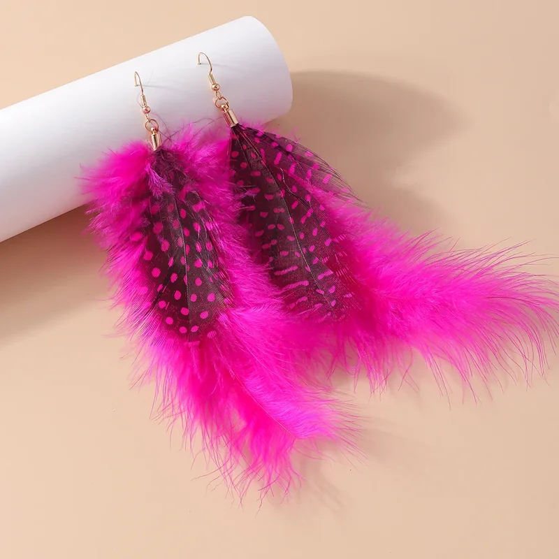 A pair of vivid pink plume drop earrings with darker spotted feather accents and a wispy outer fringe.