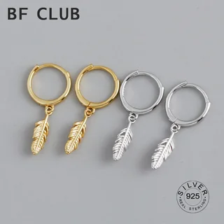 Two pairs of small hoop earrings in gold and silver tones, each with a small dangling feather-shaped charm.