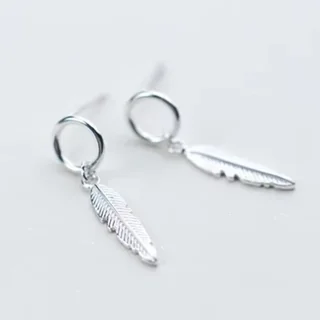A pair of silver-toned drop earrings featuring a small circular hoop attached to a textured, elongated feather-shaped metal charm.