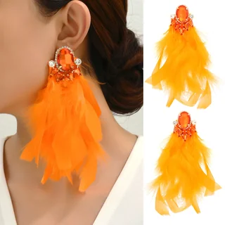 A person wearing bright orange Gala Feather Drops with a faceted stone stud and long feathers.