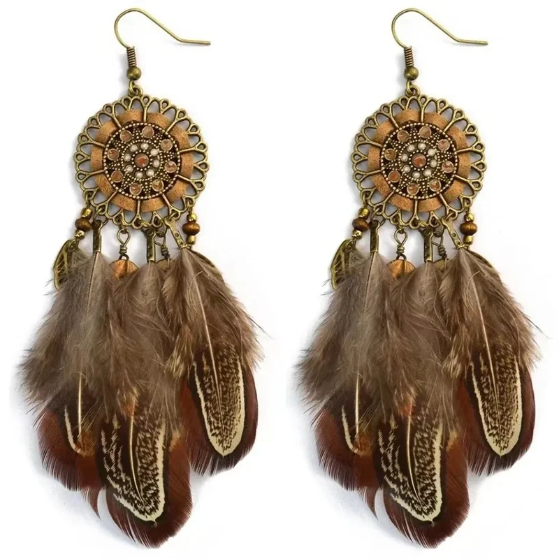 Two earrings featuring bronze-tone circular medallions with openwork, beads, and brown-toned feathers.