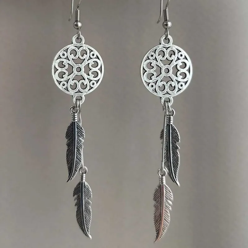 Silver-toned drop earrings featuring a circular openwork medallion and multiple hanging metal feathers.
