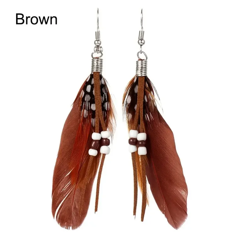 A pair of brown-toned drop earrings featuring spotted feathers, suede-like cords, and white and brown beads.