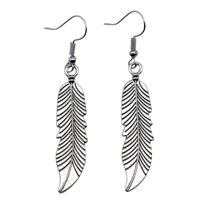 A pair of silver-toned metal feather earrings with cutout details hanging from hook wires.