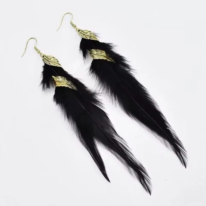 Two long, dark feather drop earrings with metallic gold-tone leaf accents on wire hooks.