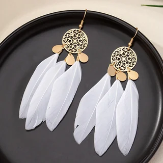 A pair of earrings with a gold-tone openwork disc top and multiple white plumes hanging from the bottom.