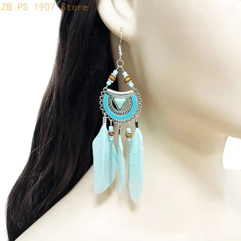 Drop earrings featuring a blue half-moon frame, small beads, silver-tone chains, and light blue feathers.