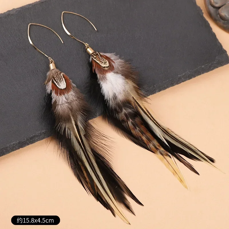 Two long, layered plume drop earrings with patterned brown and white tops tapering into dark, slender tips.