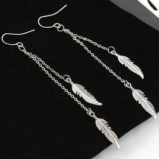 A pair of drop earrings with three thin chains of varying lengths, each ending in a small, engraved metal feather.
