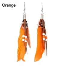 Orange beaded feather drop earrings on a plain background.