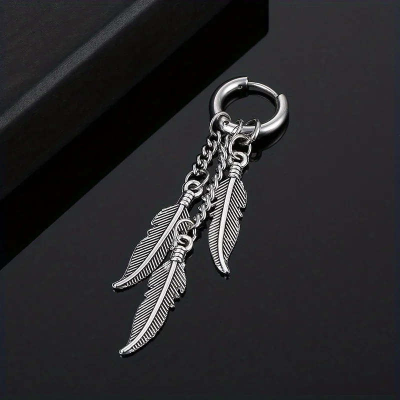 A single silver-toned hoop earring with three small, etched feather-shaped metal charms dangling from it.