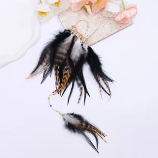 Wild Current Feather Ear Cuff showing a large cluster of black and brown feathers with a long chain ending in a small feather.