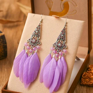 Drop earrings with a diamond-shaped geometric metal top, beaded strands, and soft plumes.