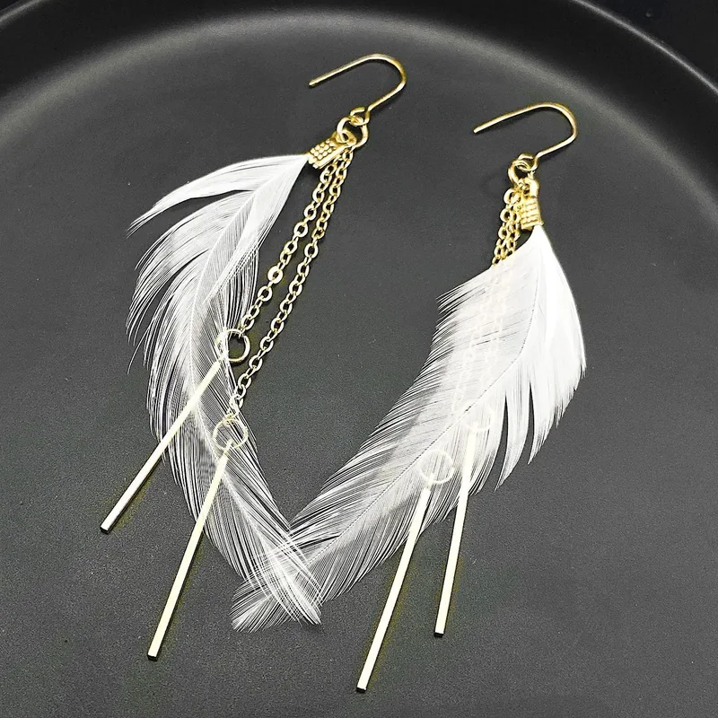 Two drop earrings featuring a single white plume, a fine chain, and a long, thin metallic bar.